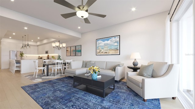 living room featuring ceiling fan with notable chandelier and hardwood / wood-style floors