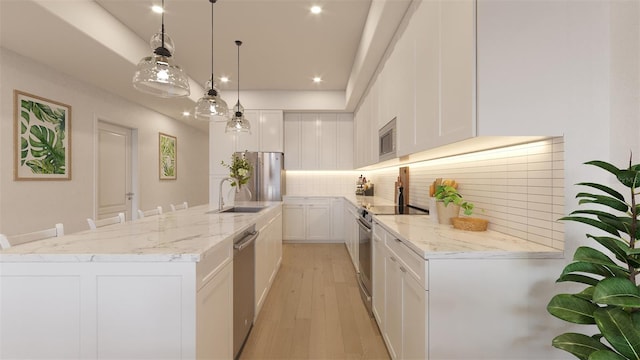 kitchen featuring pendant lighting, decorative backsplash, a kitchen breakfast bar, stainless steel appliances, and white cabinets