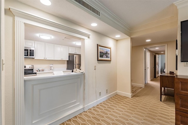 kitchen featuring visible vents, appliances with stainless steel finishes, light countertops, crown molding, and white cabinetry