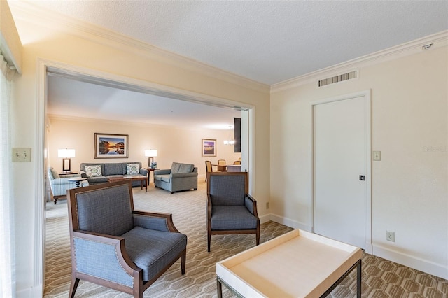 living area featuring baseboards, visible vents, a textured ceiling, and ornamental molding