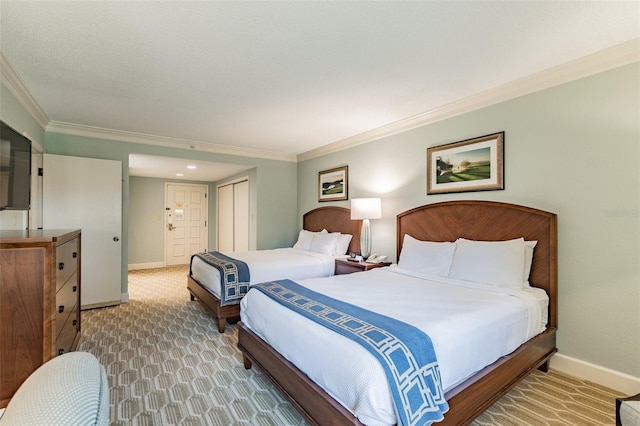 bedroom featuring ornamental molding, a closet, carpet, and baseboards