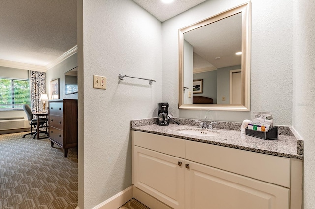 bathroom featuring baseboards, a textured wall, a textured ceiling, vanity, and crown molding