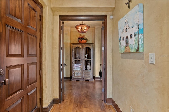 corridor with hardwood / wood-style flooring