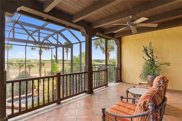 sunroom featuring ceiling fan, wooden ceiling, and beam ceiling