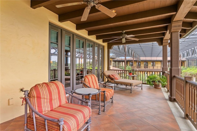 sunroom / solarium with beam ceiling, ceiling fan, and wooden ceiling