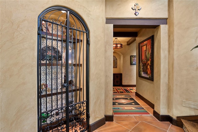 interior space with beam ceiling and dark tile patterned flooring