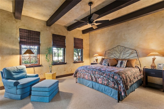 bedroom featuring ceiling fan, light colored carpet, and beamed ceiling