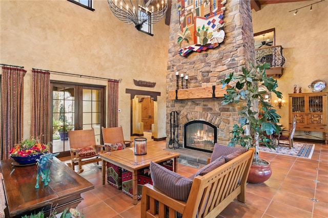 tiled living room featuring an inviting chandelier, a fireplace, and a high ceiling