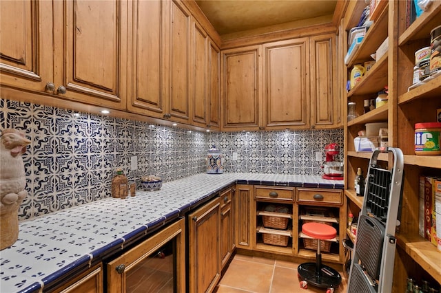 kitchen with light tile patterned floors, tile countertops, beverage cooler, and tasteful backsplash