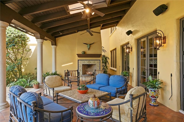 view of patio / terrace with ceiling fan and an outdoor living space with a fireplace