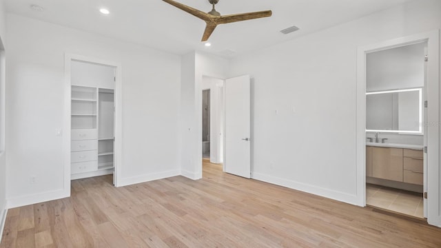 unfurnished bedroom with a walk in closet, recessed lighting, visible vents, light wood-style flooring, and baseboards