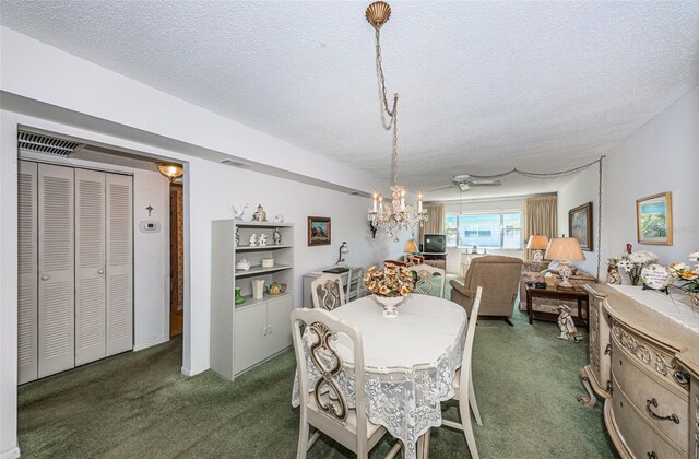 carpeted dining area with a textured ceiling and a notable chandelier