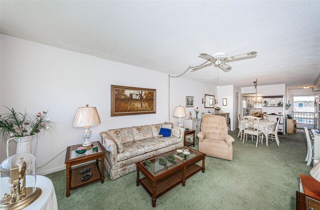 living room featuring ceiling fan, carpet floors, and a textured ceiling