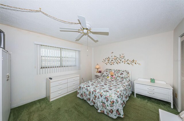 bedroom featuring dark colored carpet, ceiling fan, and a textured ceiling