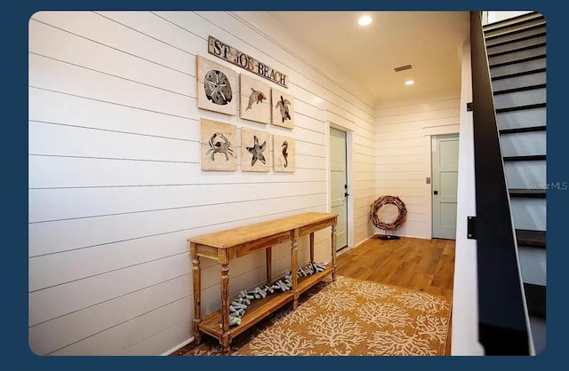 interior space featuring hardwood / wood-style flooring and wooden walls