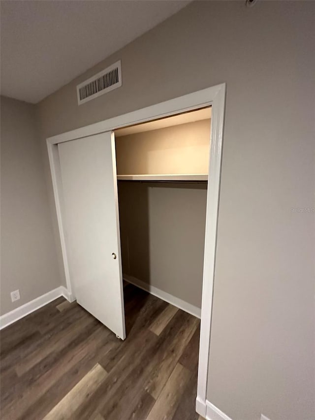 unfurnished bedroom featuring dark hardwood / wood-style flooring and a closet