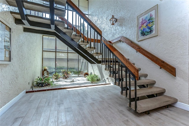 stairway with light hardwood / wood-style floors