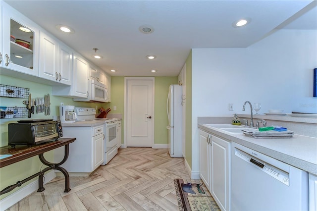 kitchen with white cabinetry, white appliances, sink, and light parquet floors