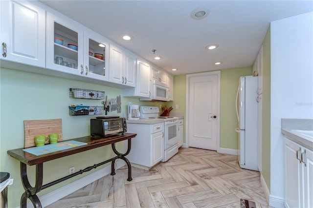 kitchen with light parquet floors, white appliances, and white cabinetry