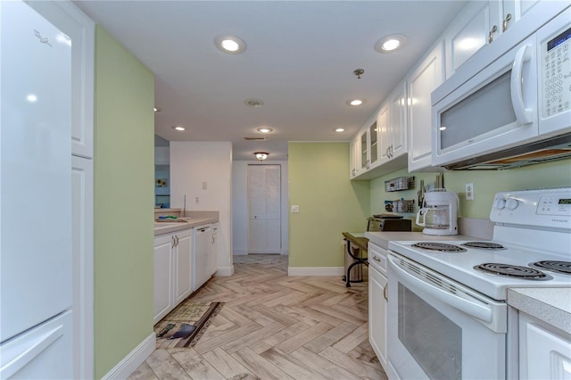 kitchen featuring white appliances, white cabinets, and light parquet flooring