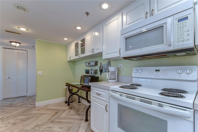 kitchen featuring white appliances, white cabinetry, and light parquet floors