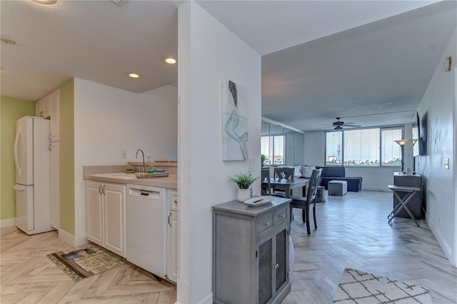 kitchen featuring white cabinetry, ceiling fan, white appliances, sink, and light parquet floors