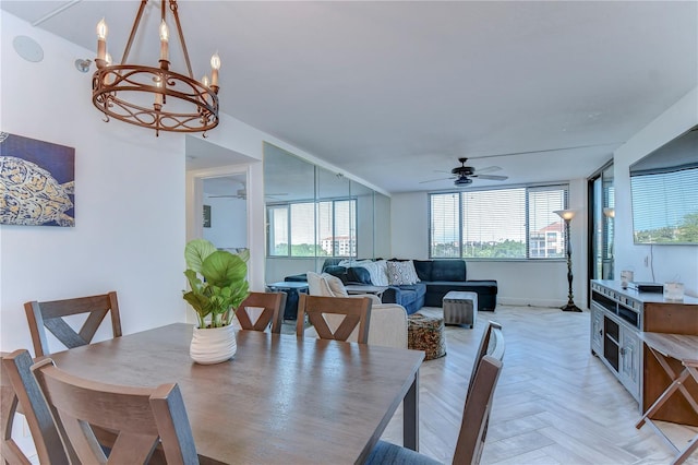 dining room featuring light parquet flooring and ceiling fan with notable chandelier