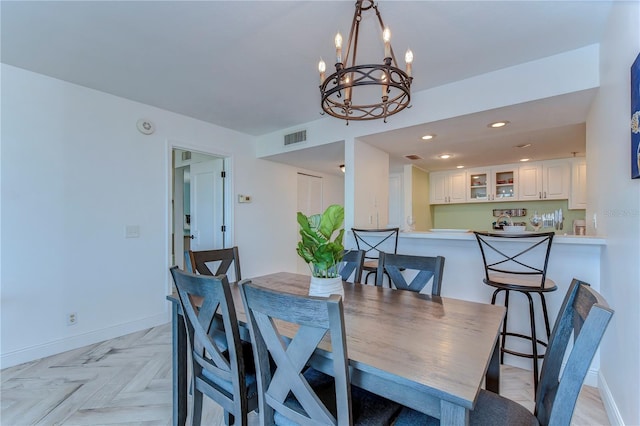 dining space featuring an inviting chandelier and light parquet floors