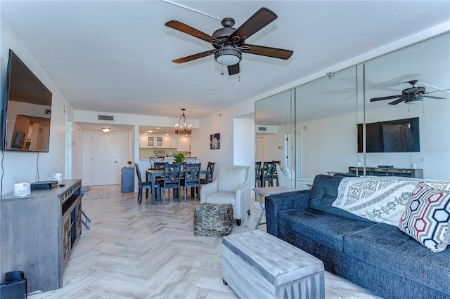 living room with light parquet floors and ceiling fan with notable chandelier