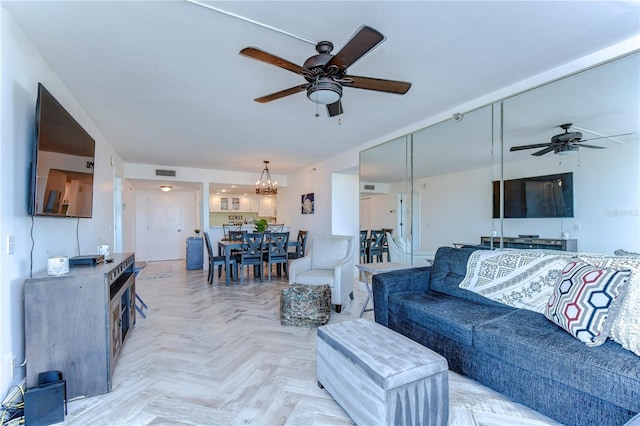 living room with ceiling fan with notable chandelier and light parquet floors