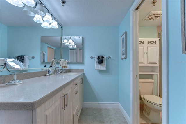 bathroom featuring tile flooring, vanity with extensive cabinet space, and toilet