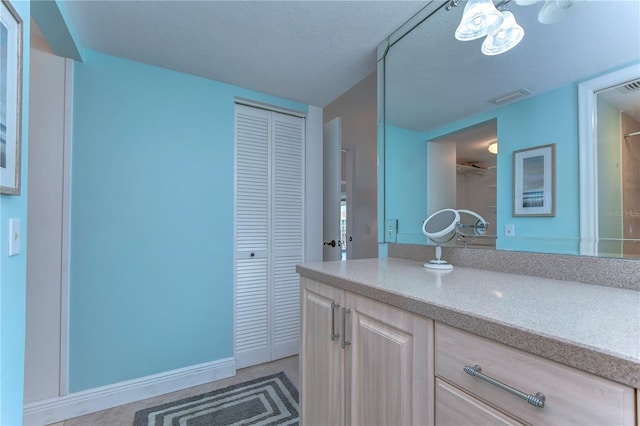 bathroom with a notable chandelier and vanity with extensive cabinet space