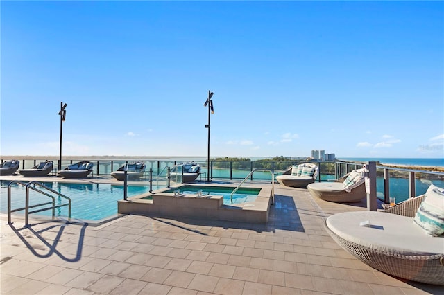 view of pool featuring a patio area, a hot tub, and a water view