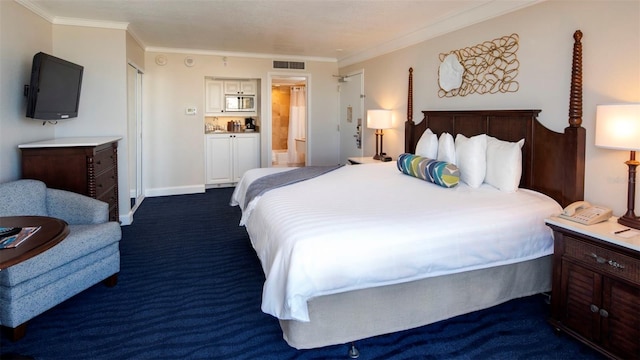 bedroom featuring ornamental molding, ensuite bathroom, and dark carpet