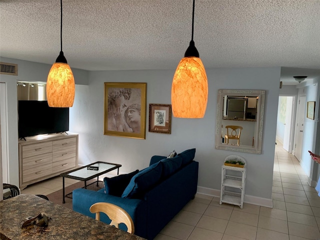 tiled living room featuring a textured ceiling