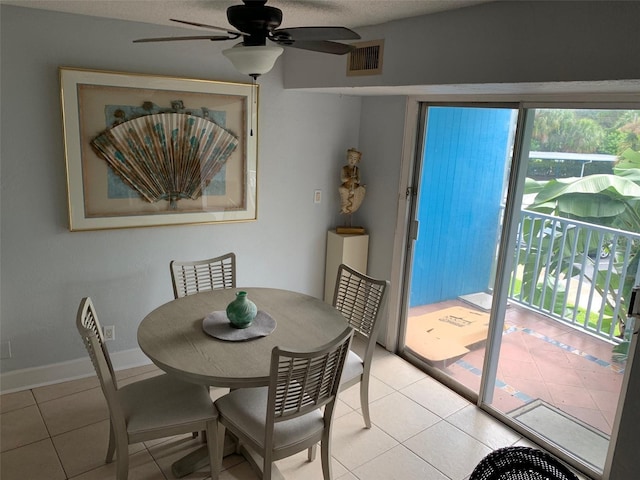 tiled dining room featuring a textured ceiling and ceiling fan