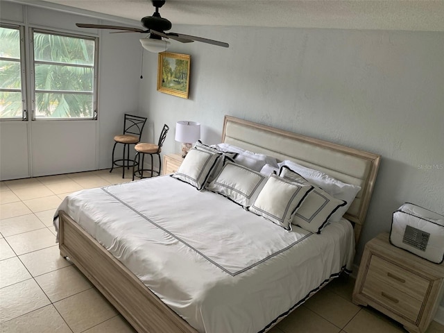 tiled bedroom with a textured ceiling and ceiling fan