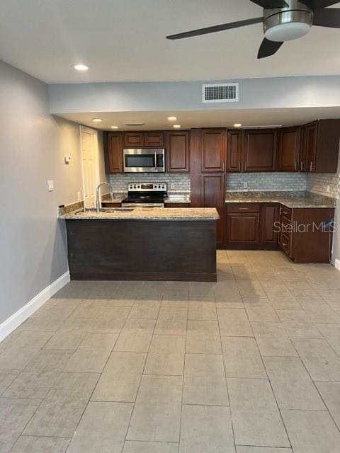 kitchen with tasteful backsplash, ceiling fan, appliances with stainless steel finishes, and light tile floors