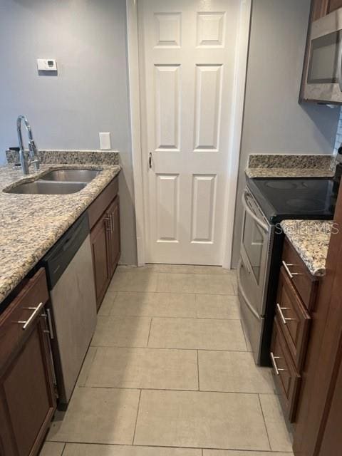 laundry room featuring light tile floors and sink