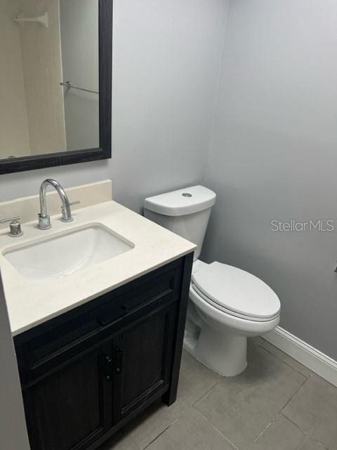 bathroom featuring toilet, tile floors, and large vanity