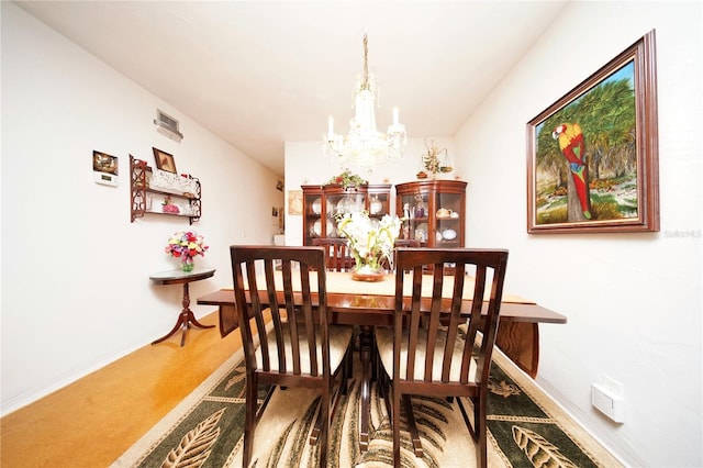 carpeted dining space featuring an inviting chandelier