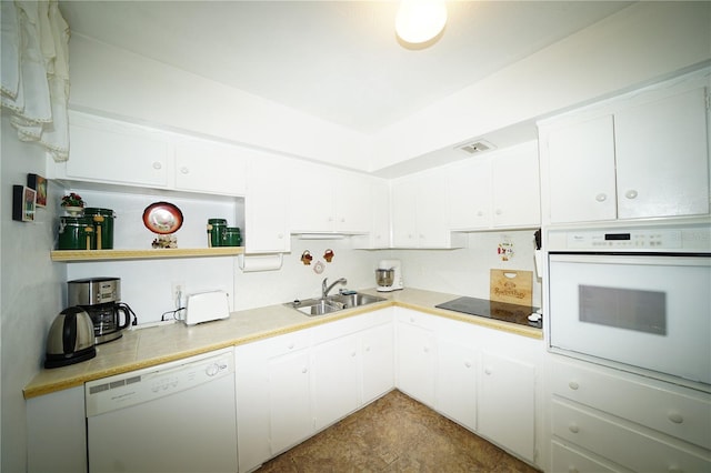 kitchen featuring visible vents, white appliances, a sink, and white cabinetry