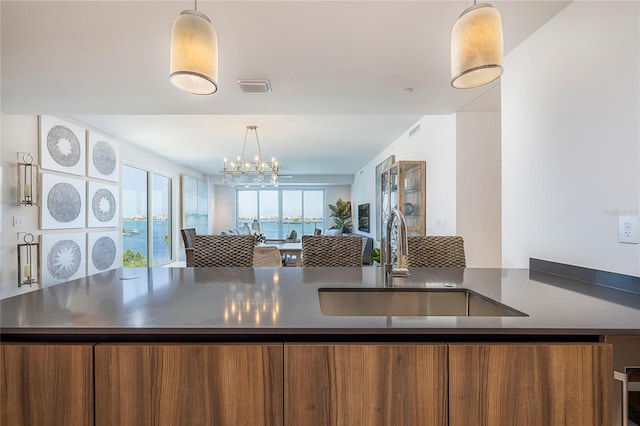 kitchen featuring pendant lighting, sink, and a notable chandelier