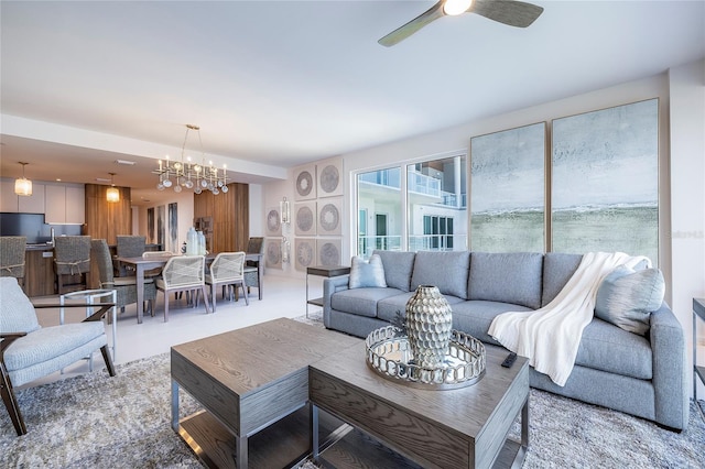 living room with ceiling fan with notable chandelier