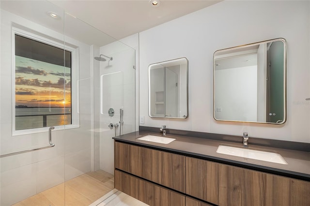 bathroom with dual vanity, tile flooring, and a shower with shower door