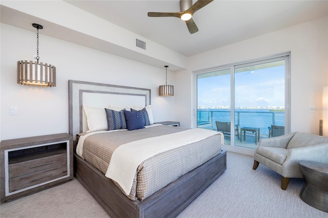 bedroom with a water view, ceiling fan with notable chandelier, light colored carpet, and access to outside