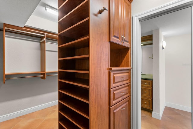 spacious closet with light tile patterned floors