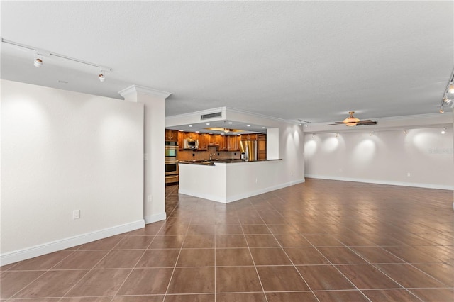 unfurnished living room featuring ceiling fan, dark tile patterned floors, rail lighting, and a textured ceiling