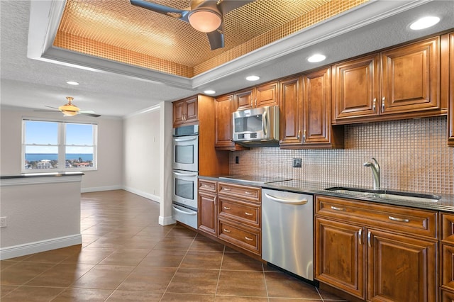 kitchen featuring ceiling fan, sink, stainless steel appliances, tasteful backsplash, and ornamental molding