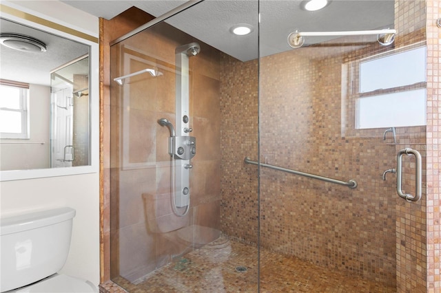 bathroom featuring toilet, a textured ceiling, and walk in shower